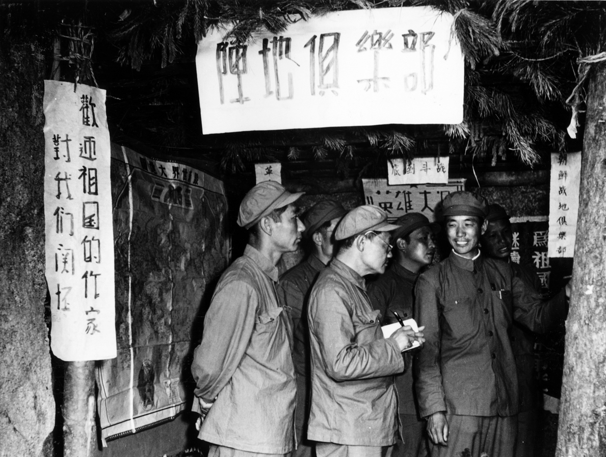 1952年。作家巴金等在中国人民志愿军某部佛国山英雄第九连阵地俱乐部，参观战士们办的.jpg